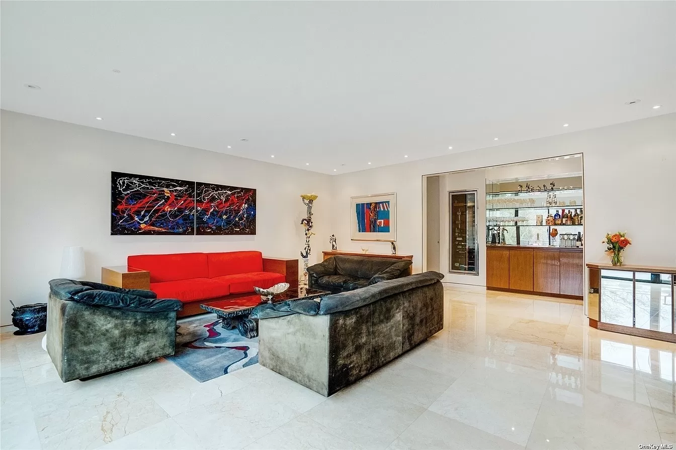 back view of woman wearing a backpack and beanie waiting to cross the road on a busy street at night in New York City, USA