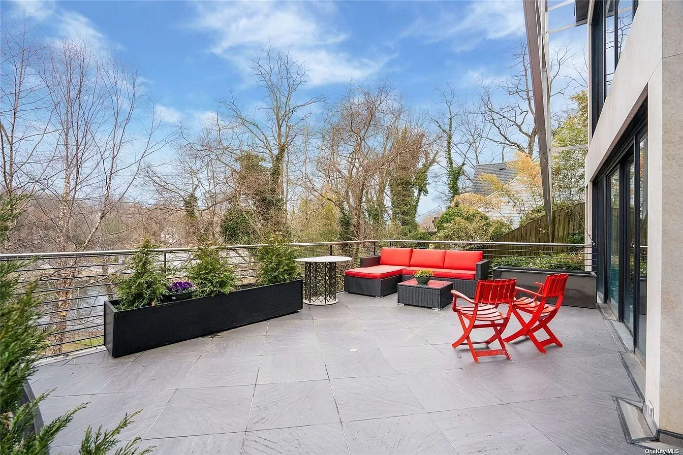 back view of woman wearing a backpack and beanie waiting to cross the road on a busy street at night in New York City, USA