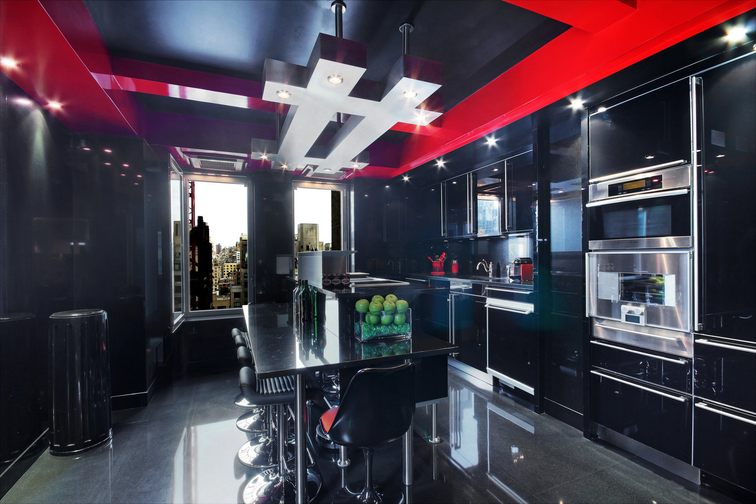 person writing in a notebook beside by an iPad, laptop, printed photos, spectacles, and a cup of coffee on a saucer